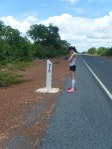 A runner and kilometer markers on the South Bank Road, The Gambia